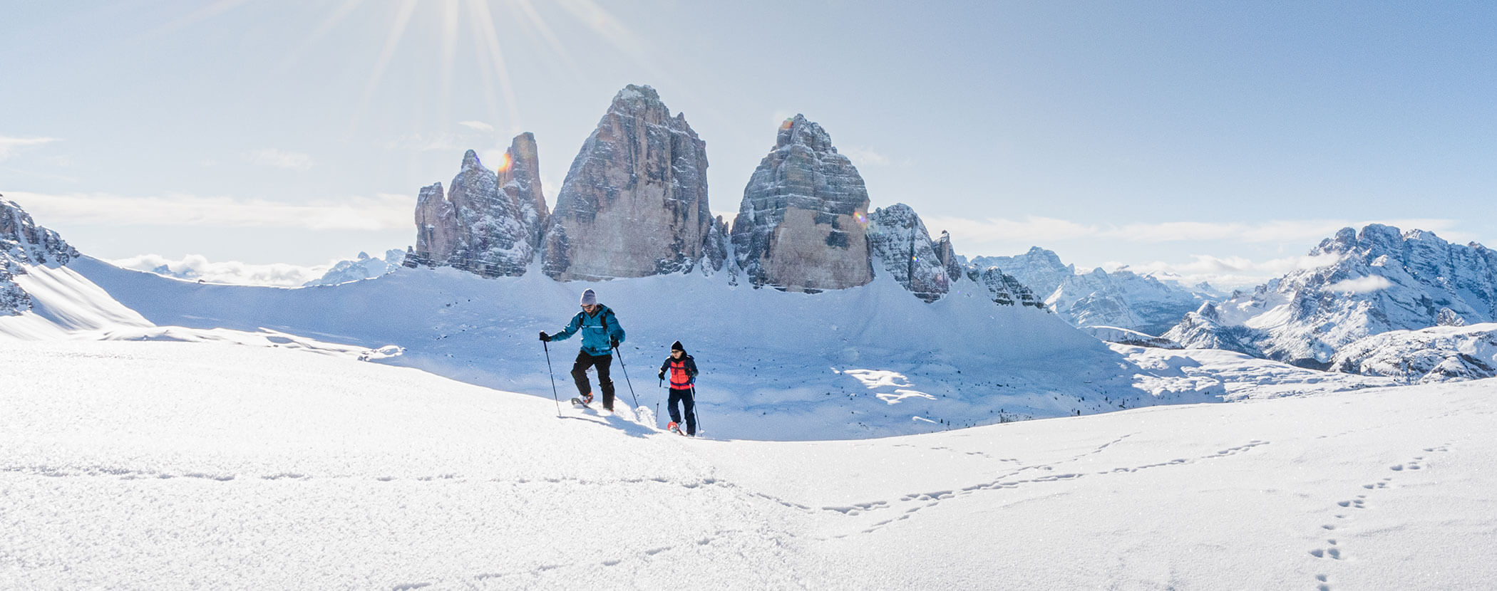 Due escursionisti con le racchette da neve su un campo di neve, con le Tre Cime alle spalle - Residenza Kurze Wand