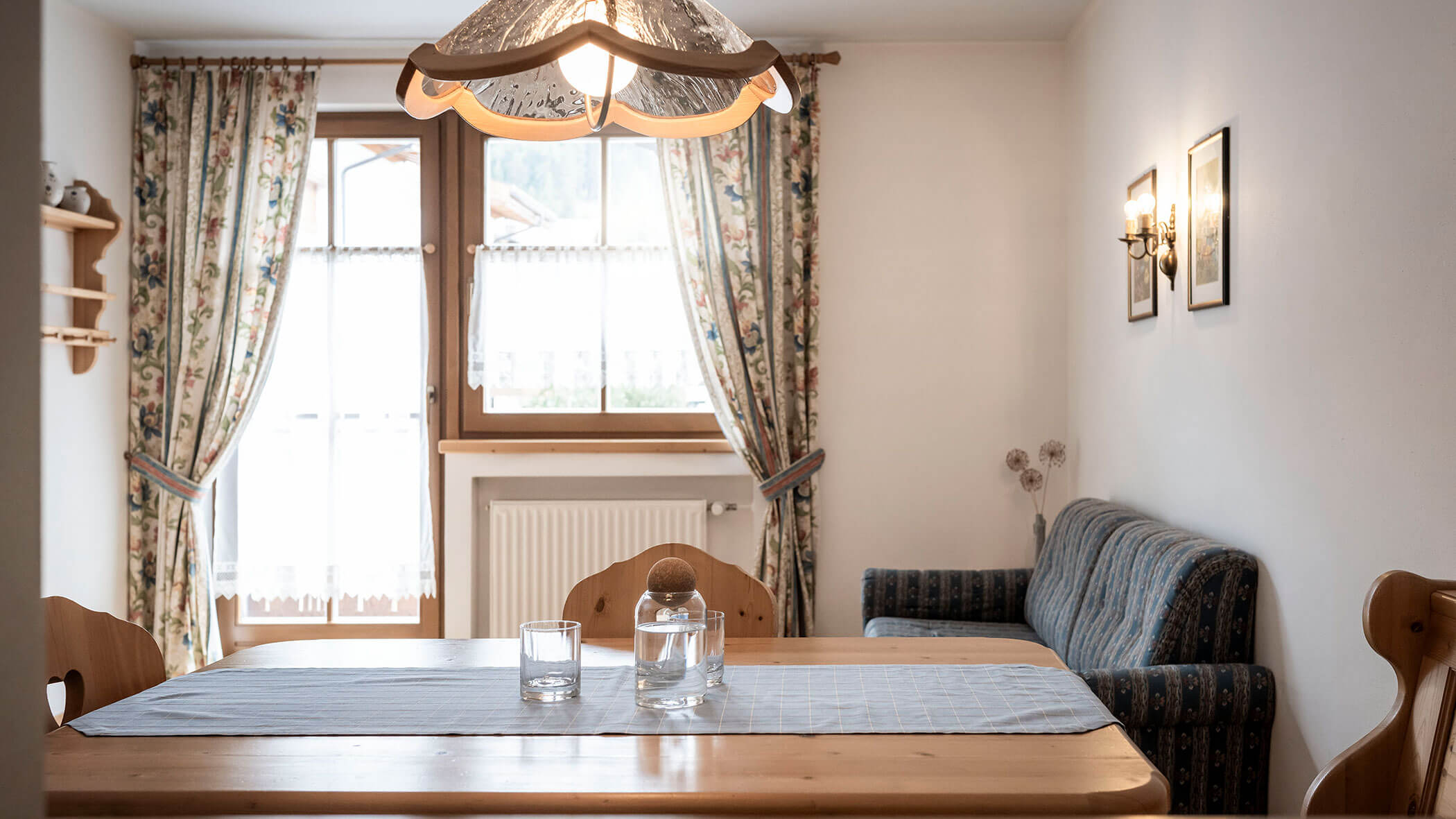 Grande tavolo in legno con caraffa d'acqua e diversi bicchieri nell'appartamento 3 - Residence Kurze Wand