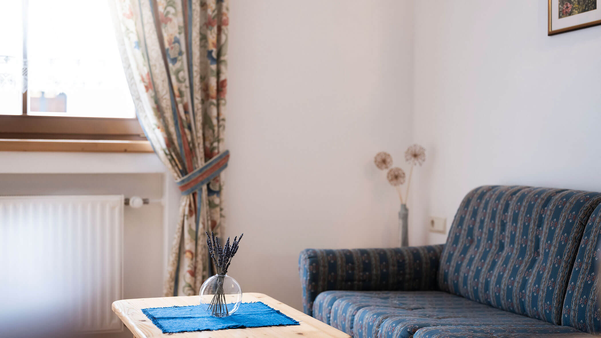 Divano blu a fantasia e tavolino con un mazzo di lavanda - Residence Kurze Wand