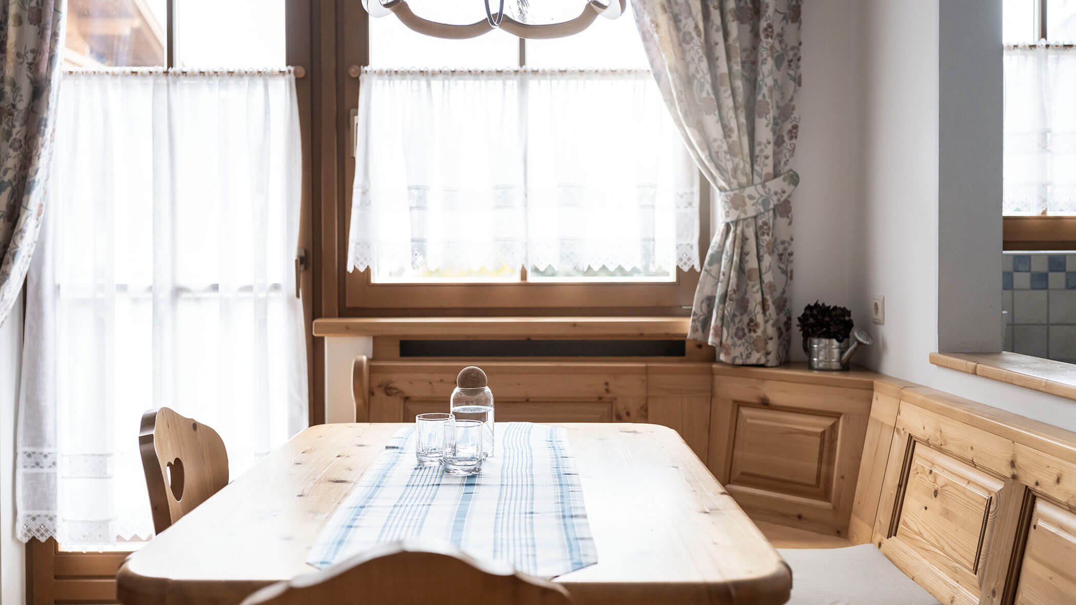 Grande tavolo in legno con caraffa d'acqua e due bicchieri nell'appartamento 4 - Residence Kurze Wand