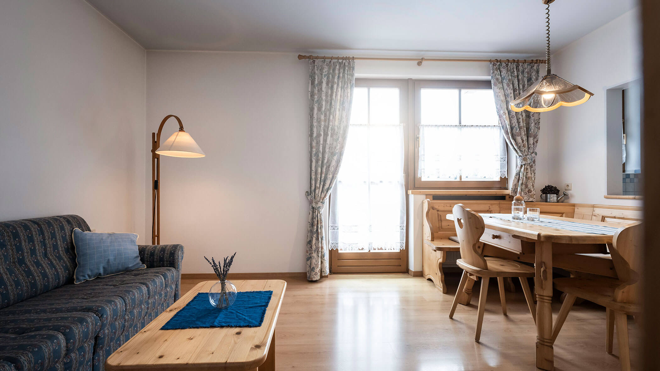 Soggiorno con divano blu e panca angolare in legno nell'appartamento 4 - Residence Kurze Wand