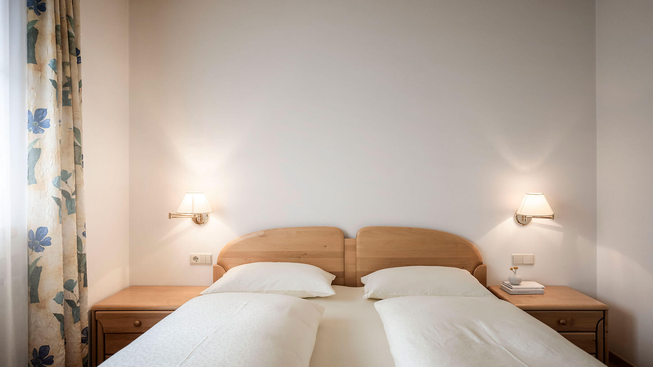 Letto matrimoniale e tende a fantasia nell'appartamento 4 - Residence Kurze Wand