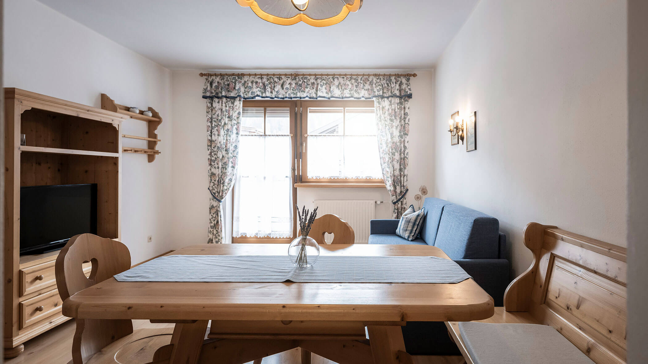 Grande tavolo in legno con runner blu e vaso nell'appartamento 5 - Residence Kurze Wand
