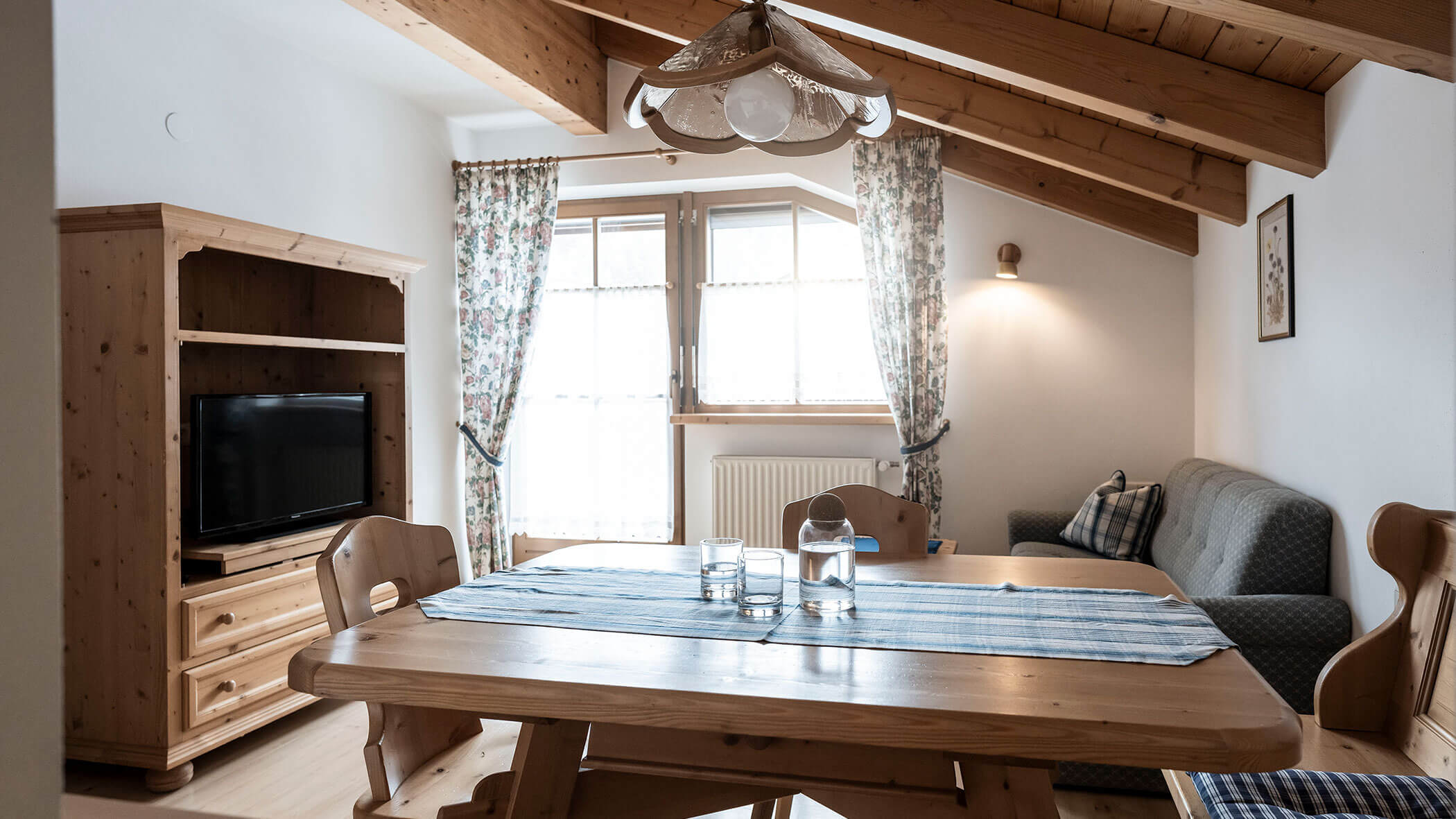 Grande tavolo in legno con runner blu e acqua nell'appartamento 6 - Residence Kurze Wand