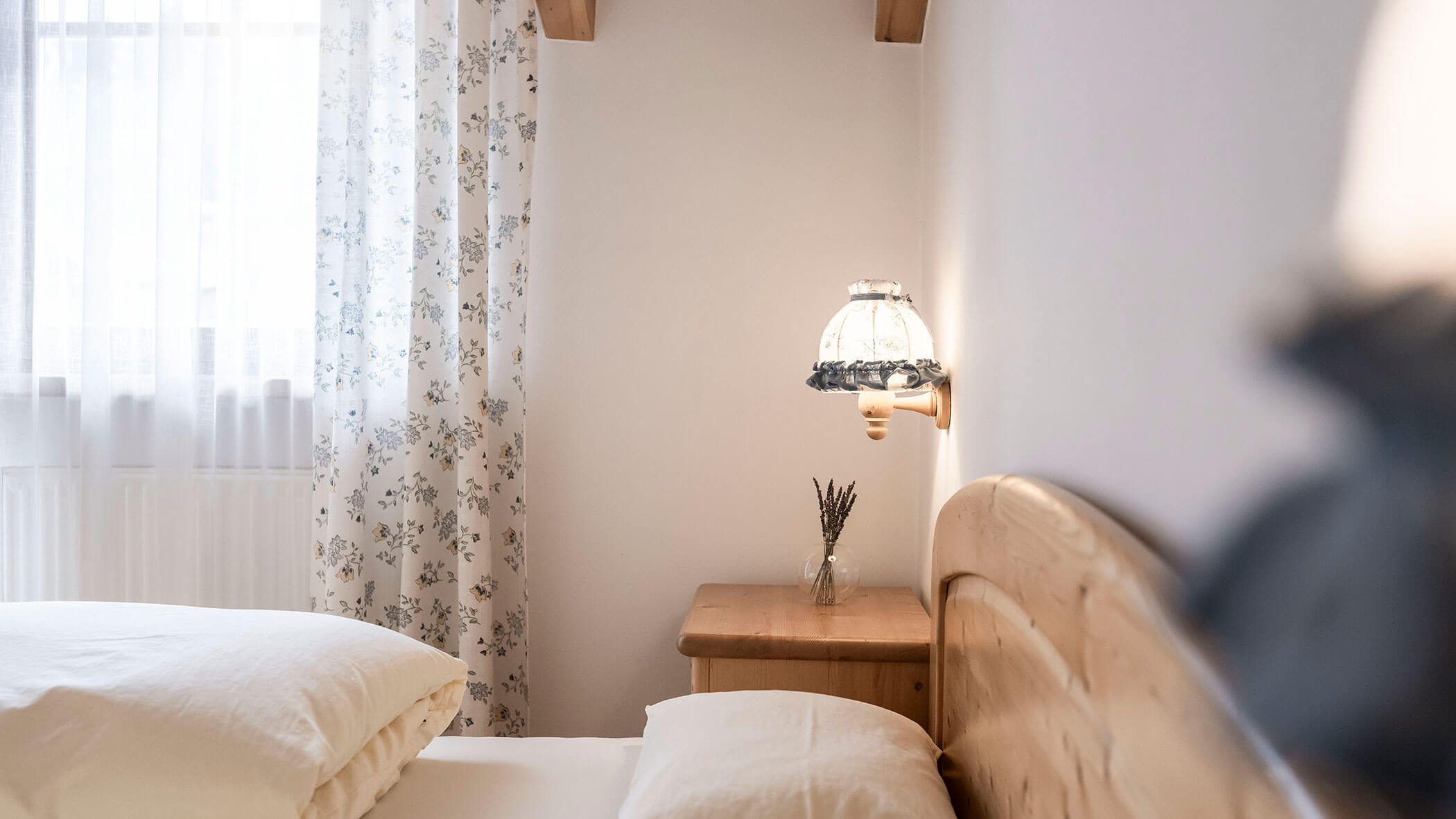 Letto matrimoniale con comodino in legno e bouquet di lavanda nell'appartamento 6 - Residence Kurze Wand