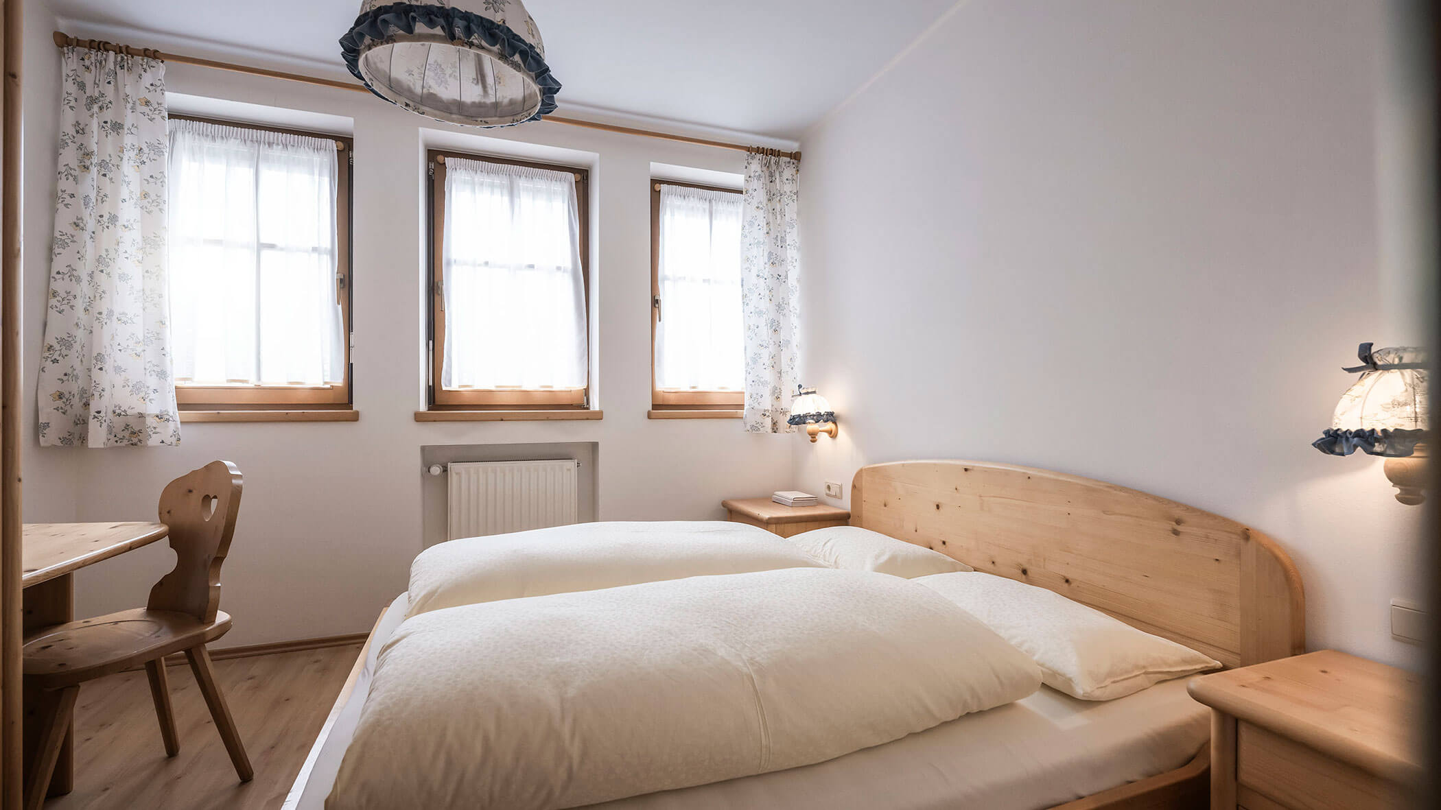 Camera da letto con letto matrimoniale e scrivania con sedia nell'Appartamento 6 - Residence Kurze Wand