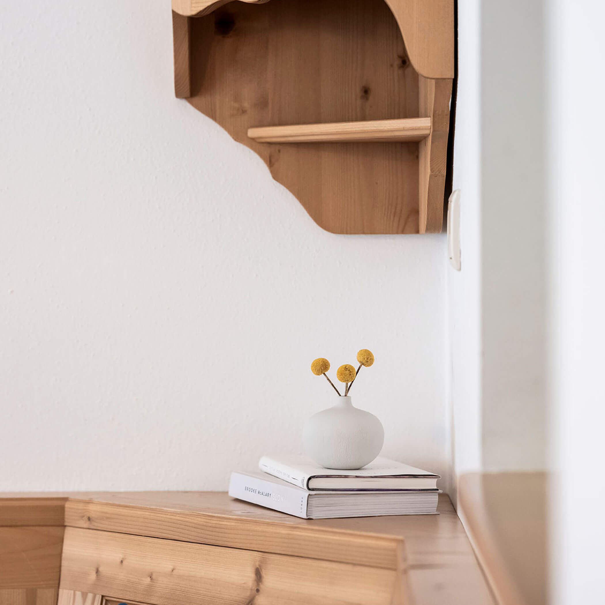 Libri e un vaso di fiori gialli nell'angolo della zona salotto - Residence Kurze Wand